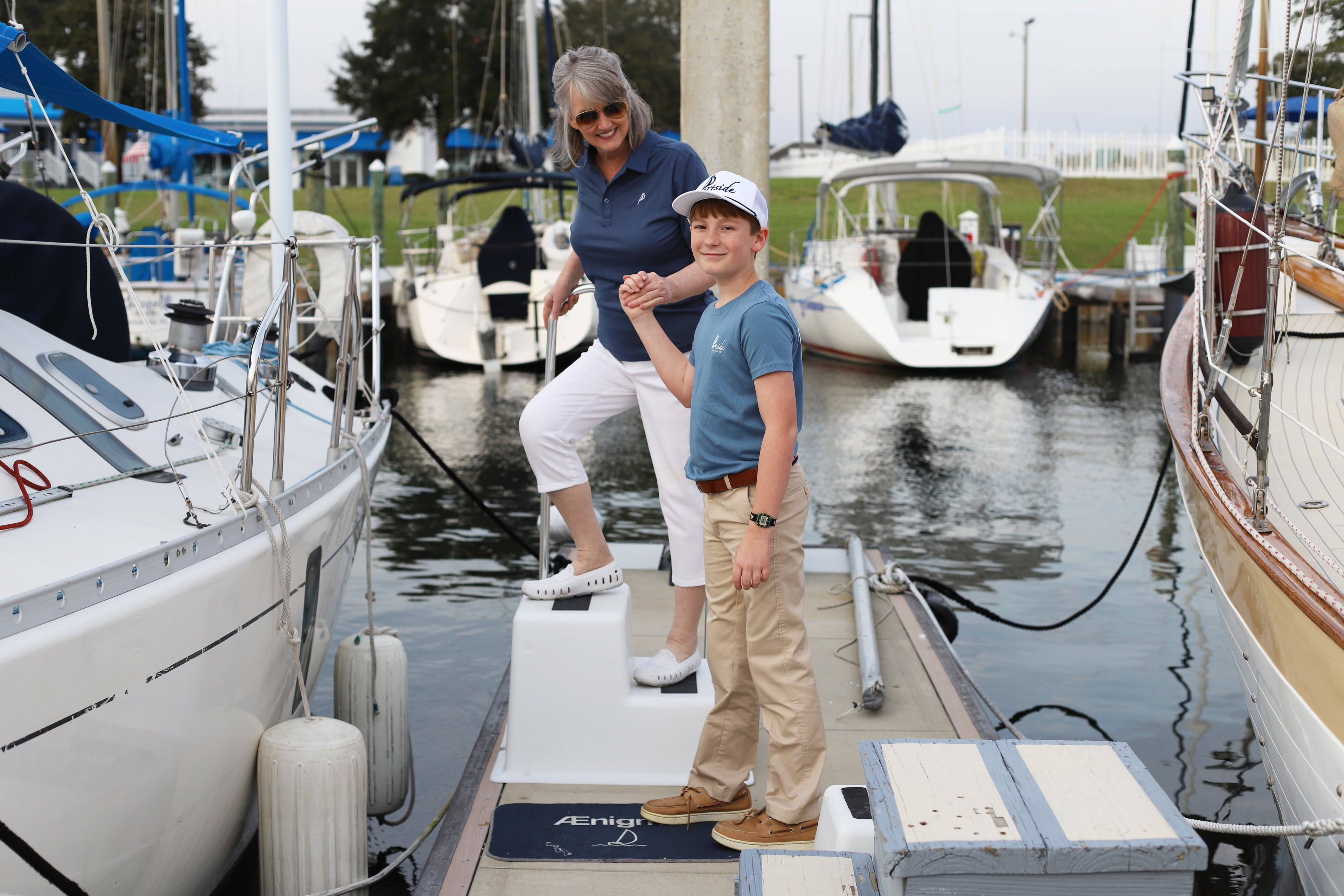 Family sporting stylish Portside Sailing Co. apparel, including a Pensacola-themed t-shirt, luxury polo, and signature hat, embracing coastal lifestyle and comfort.