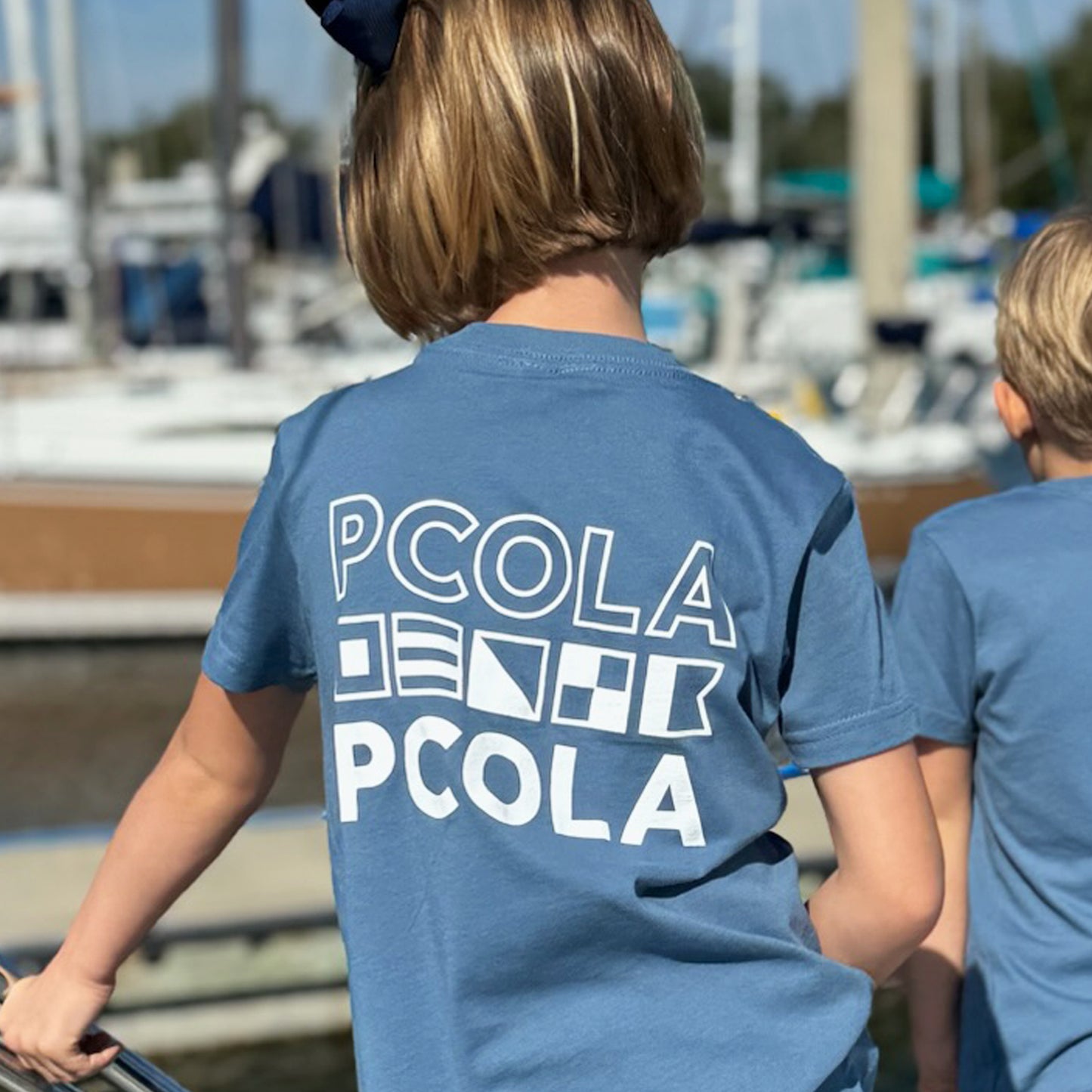 Soft, high-end kids' t-shirt featuring the iconic 'PCOLA' design, perfect for kids who love Pensacola and the beach.