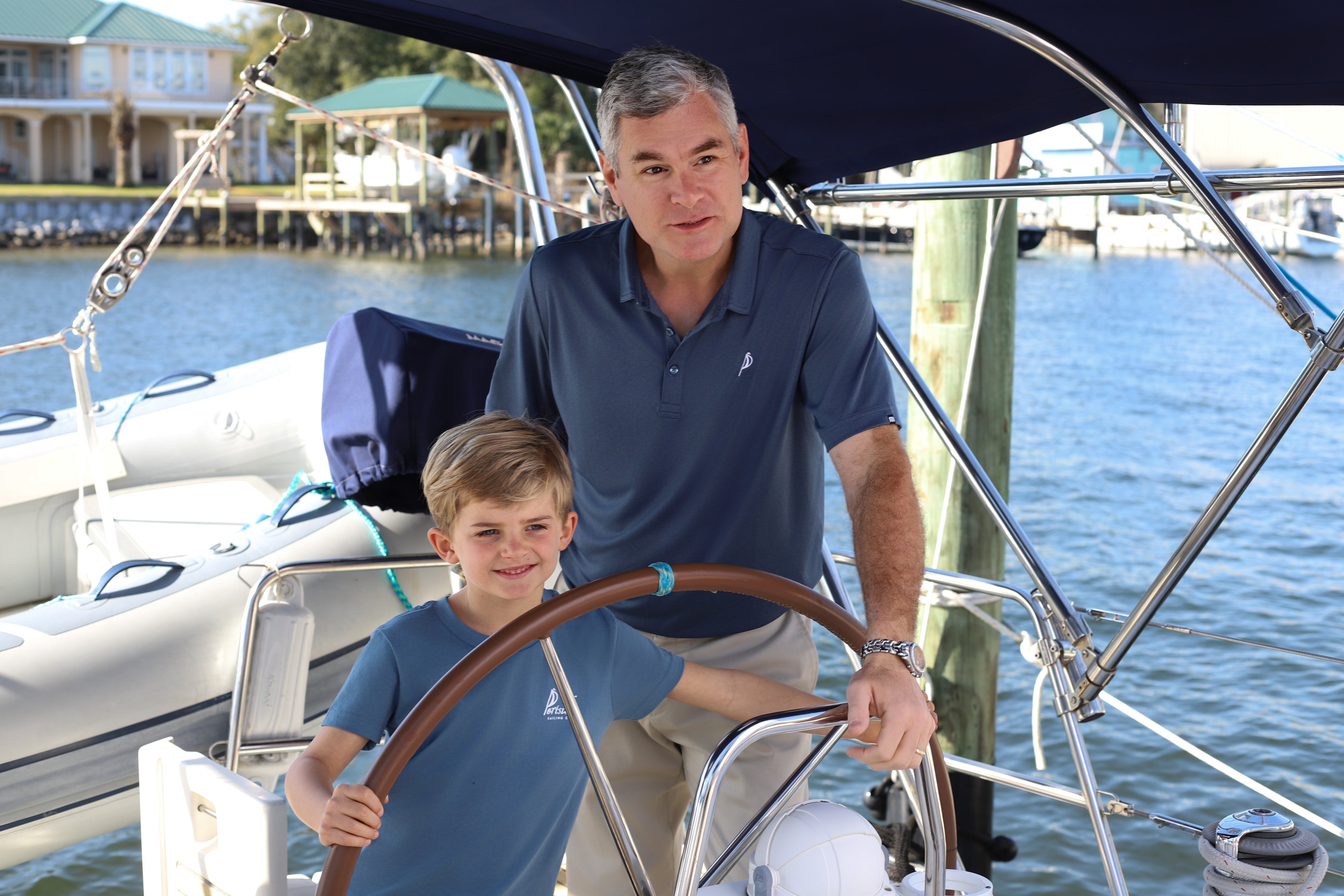 A father and son proudly wearing their Pensacola Portside clothing, reflecting a family bond and coastal lifestyle.