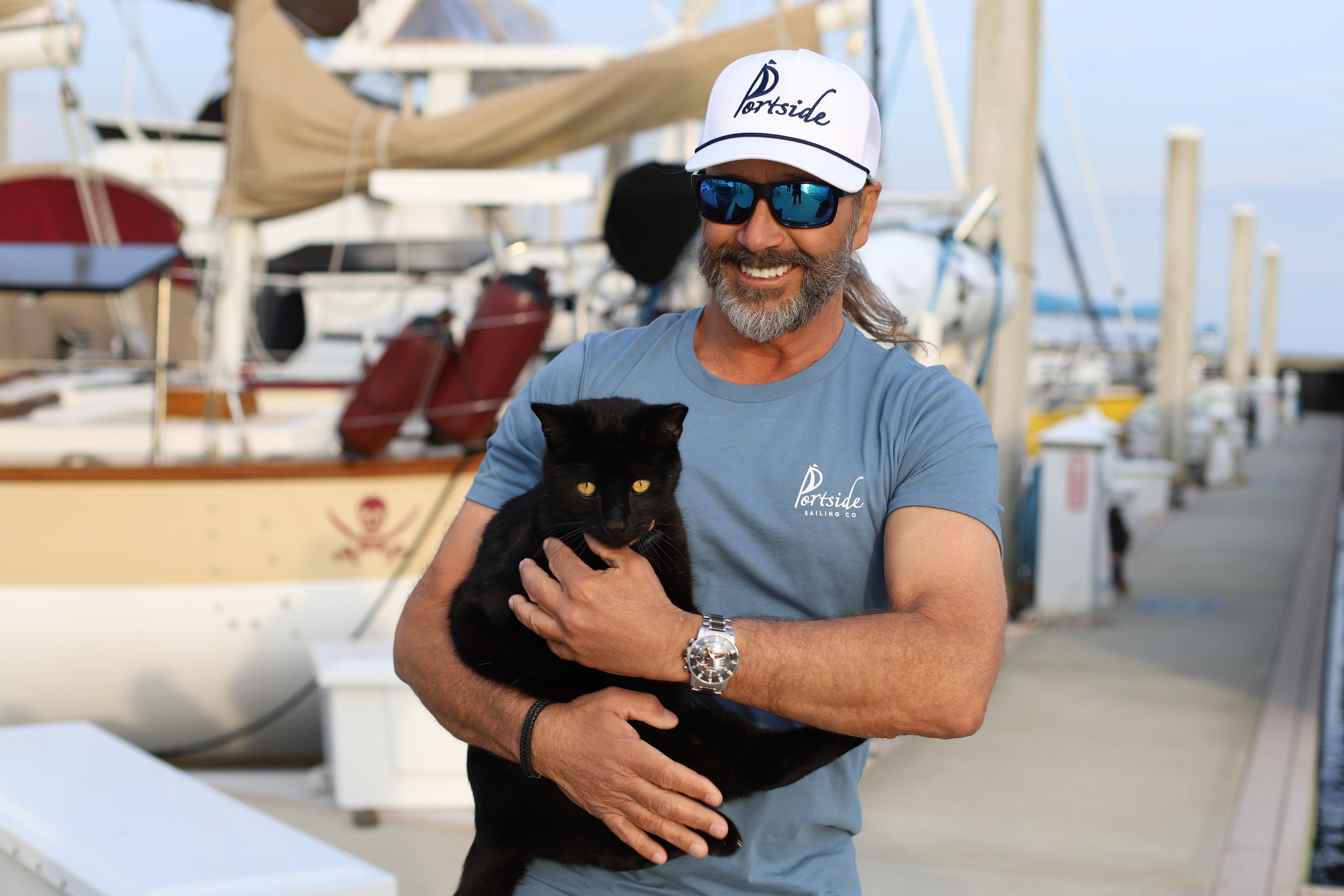High-quality adult t-shirt featuring the 'PCOLA' design, showcasing Pensacola, FL in a stylish, casual look. Classic Portside Sailing Co. hat with embroidered logo, designed for nautical enthusiasts and casual wear.