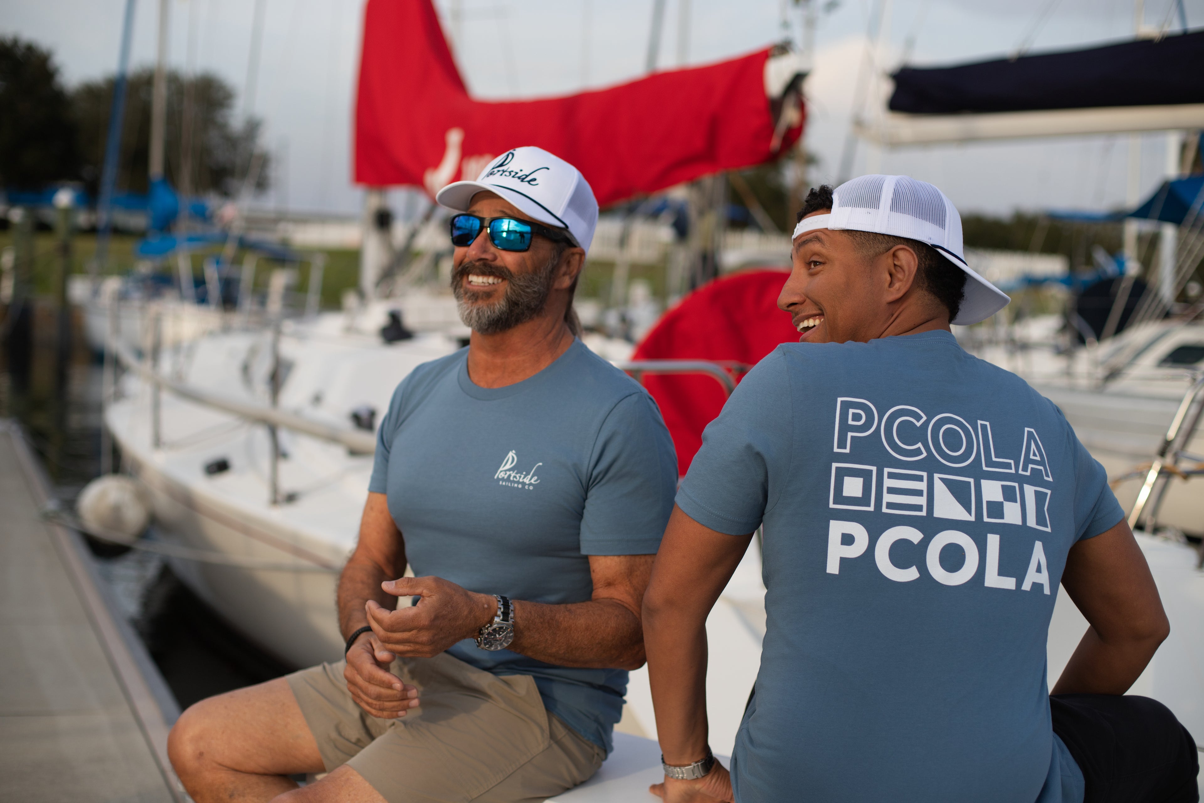Casual Portside Sailing Co. hat with embroidered branding, a perfect accessory for sailing trips or everyday wear. Premium adult t-shirt featuring the bold 'PCOLA' graphic, designed for a stylish and comfortable way to showcase Pensacola pride.