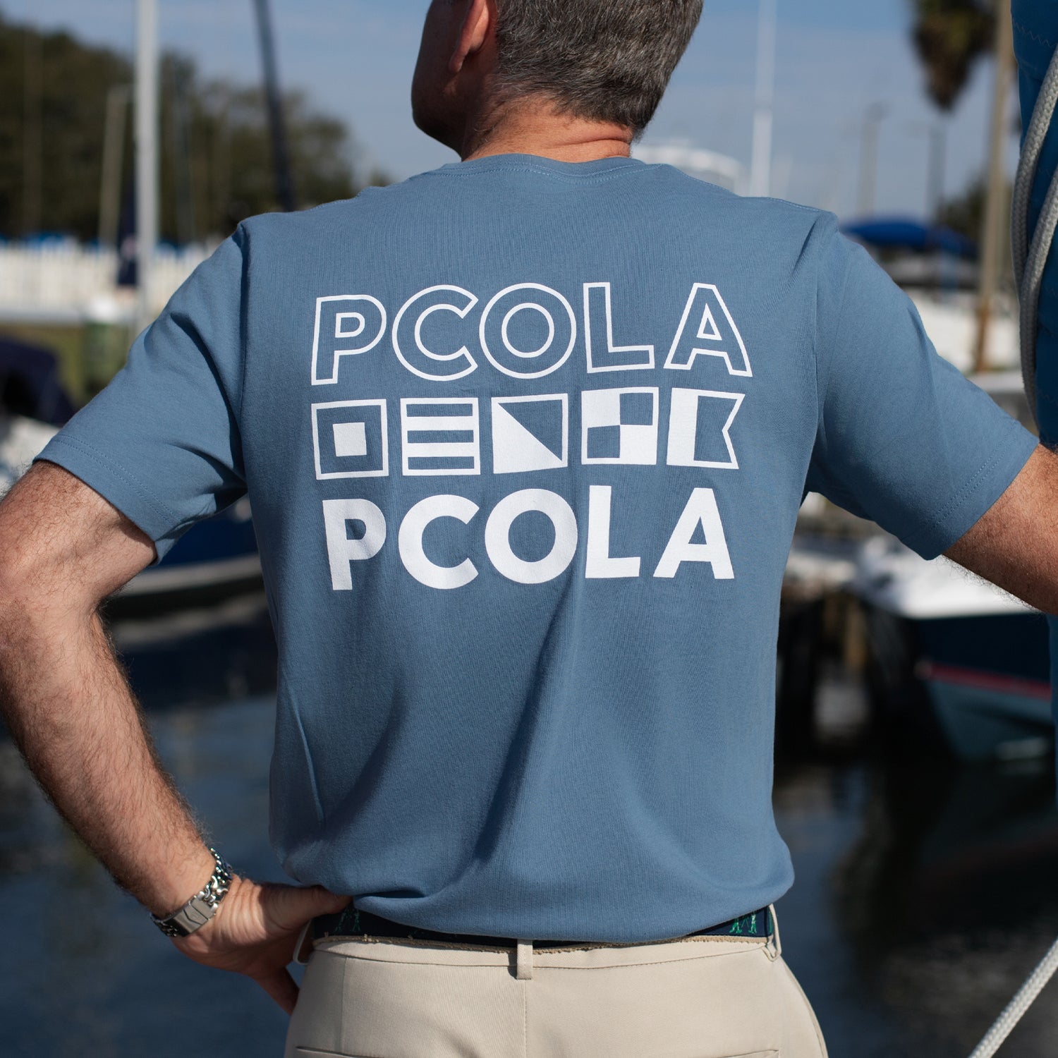 PCOLA graphic t-shirt, a high-quality shirt with a vibrant design showcasing Pensacola, FL, ideal for casual outings or beach days.